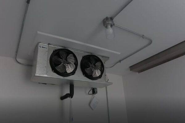Two black fans on the interior of a walk in refrigeration unit
