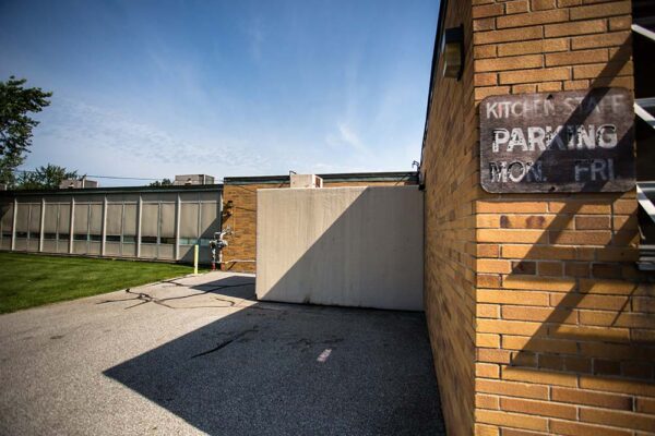Side view of brick building and grey Polar King walk-in cooler