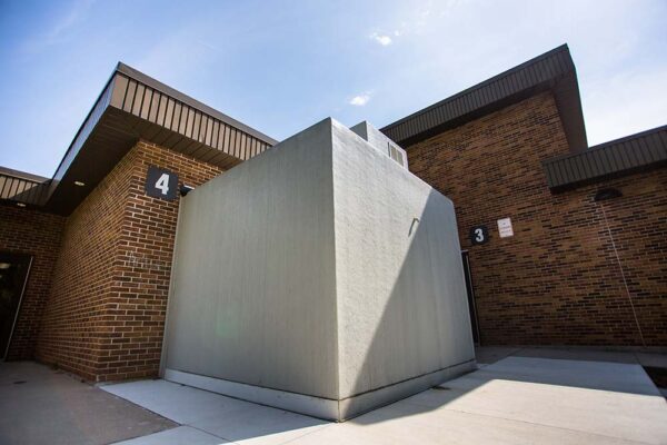 Side view of grey walk-in freezer unit attached to a brick building