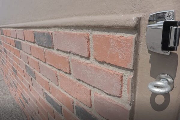 Brick wall of a Polar King cooler painted brown with a close-up on the metal lock