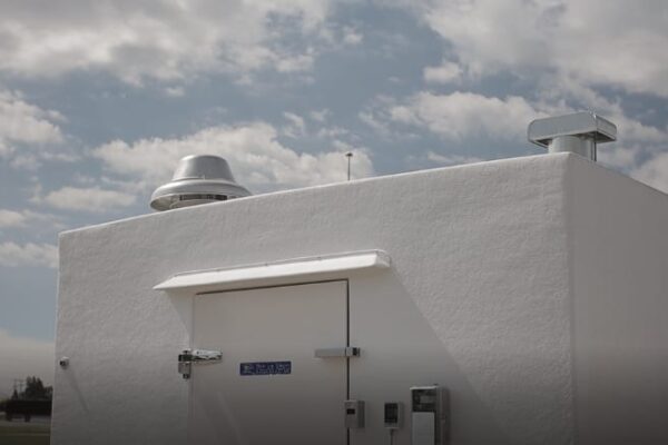 Top view of a white PKI refrigerated building in front of the blue sky
