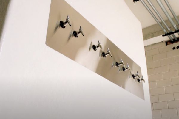 Small metal spouts on a white wall