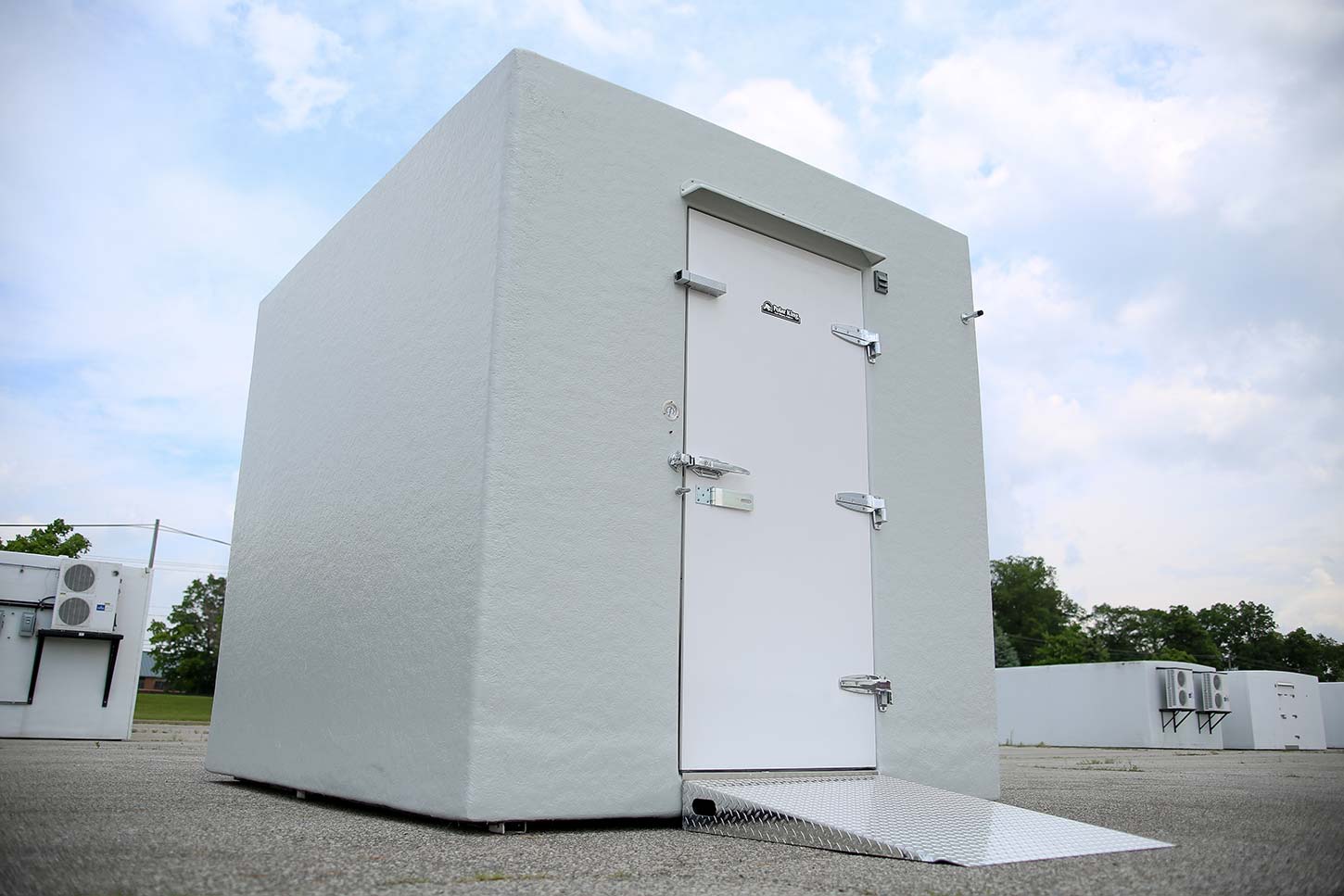 White walk-in cooler freezer combo on concrete