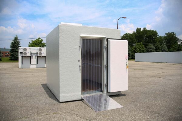 White walk-in cooler door open outside on a sunny day
