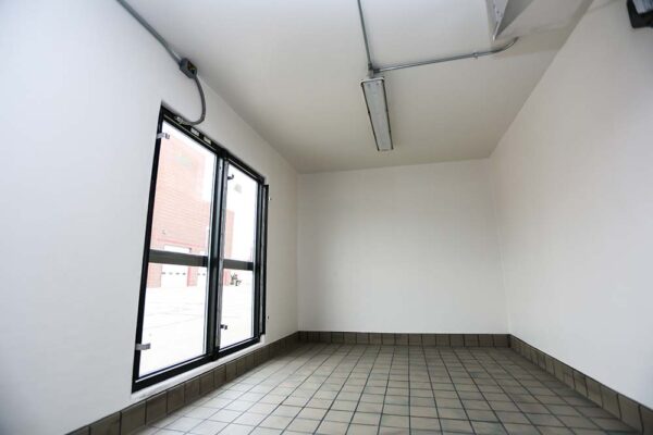 Inside of a refrigeration unit with tile floors and white walls