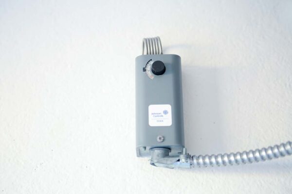 Grey temperature control on a white wall