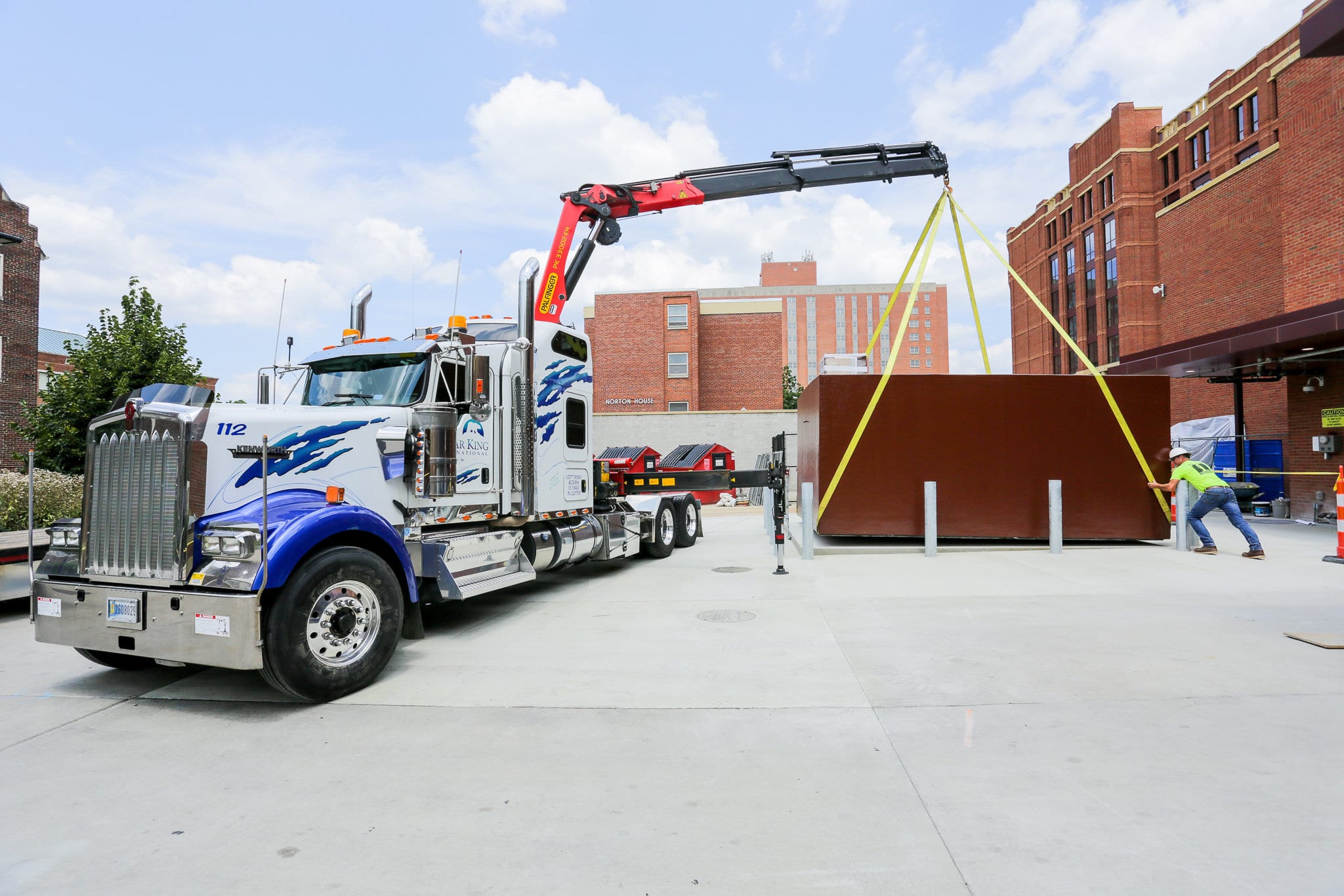 Large semi truck and a crane moving a cooler unit